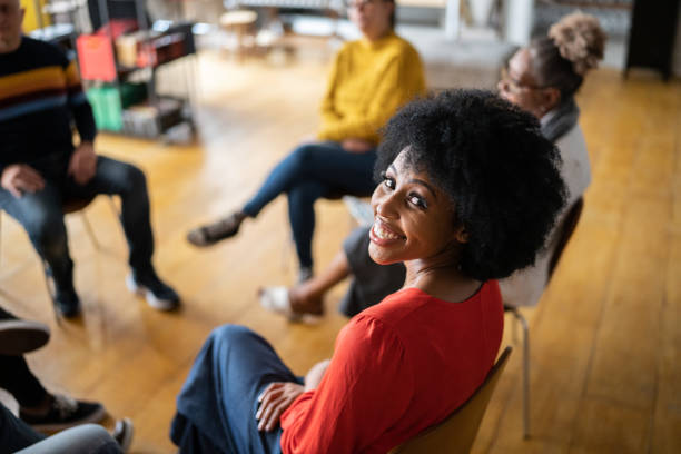 Portrait of a young woman in group therapy at a coworking